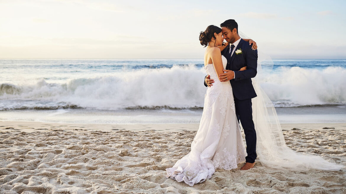 happy married couple posing on the beach